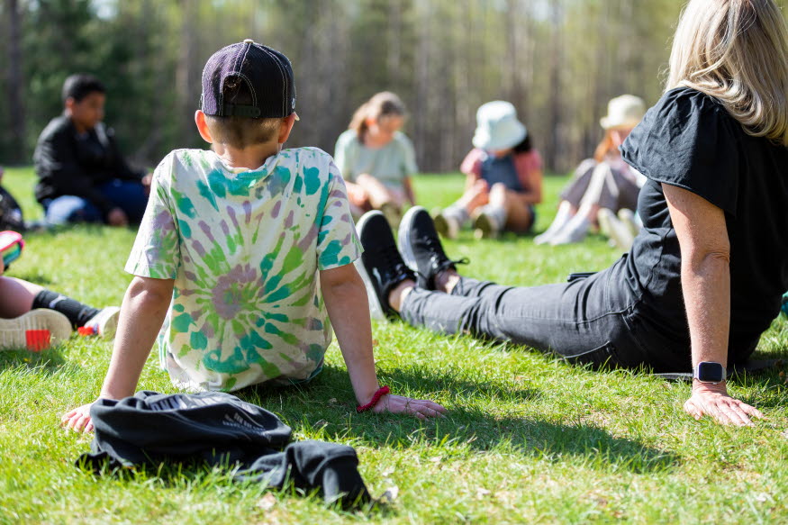 Ett barn sitter framför en ipad och deltar i en aktivitet anordnad av Komtek.