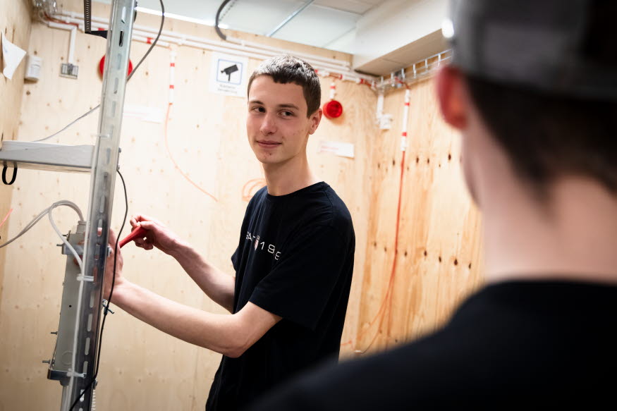 En ung person som skruvar med kablar.