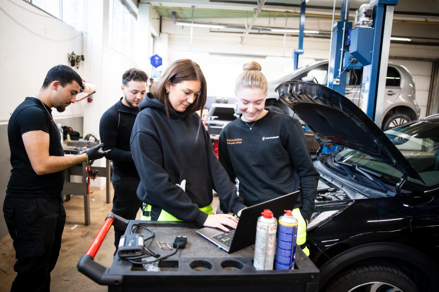Några personer i en bilverkstad.