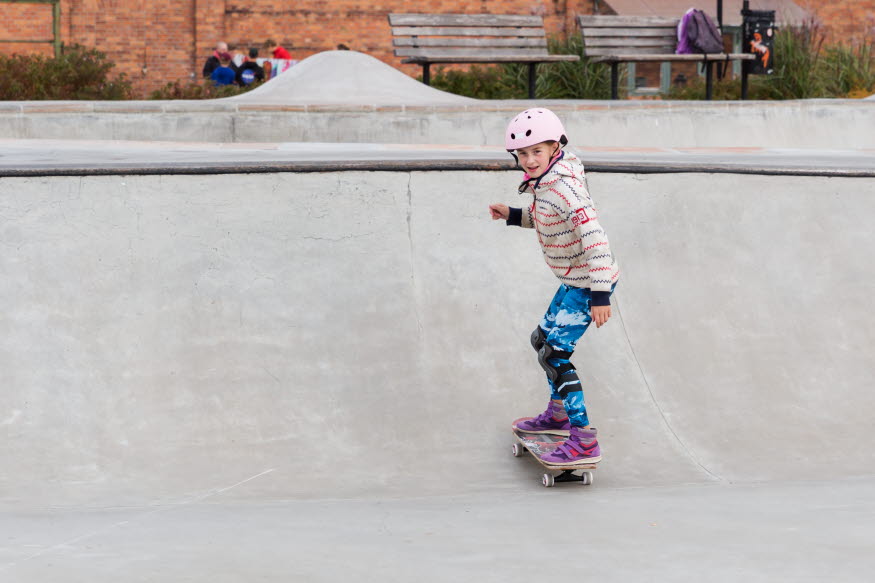 Ett barn åker skateboard i skateparken.