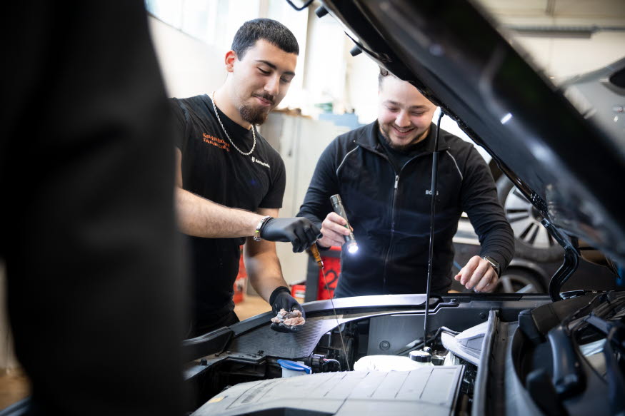 Elever som mekar med en bil.