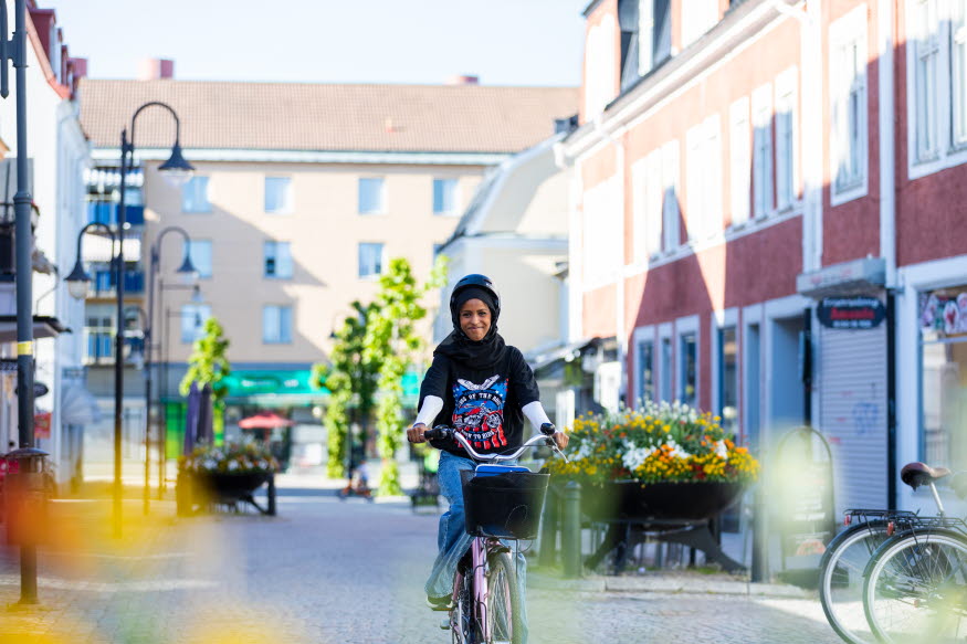 En glad person cyklar i centrala Katrineholm