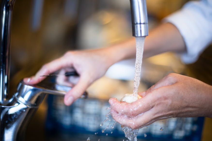 Händer och en vattenkran