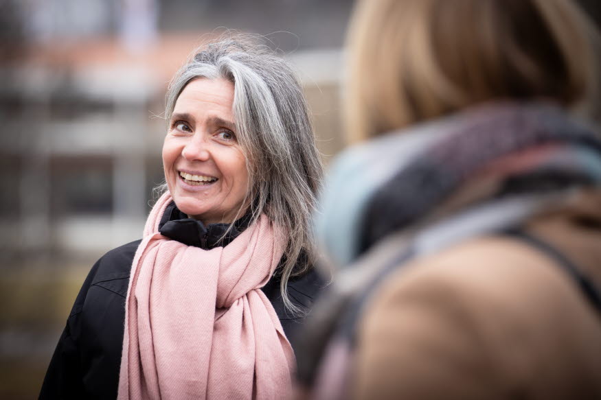 Två personer som pratar med varandra i en park. 