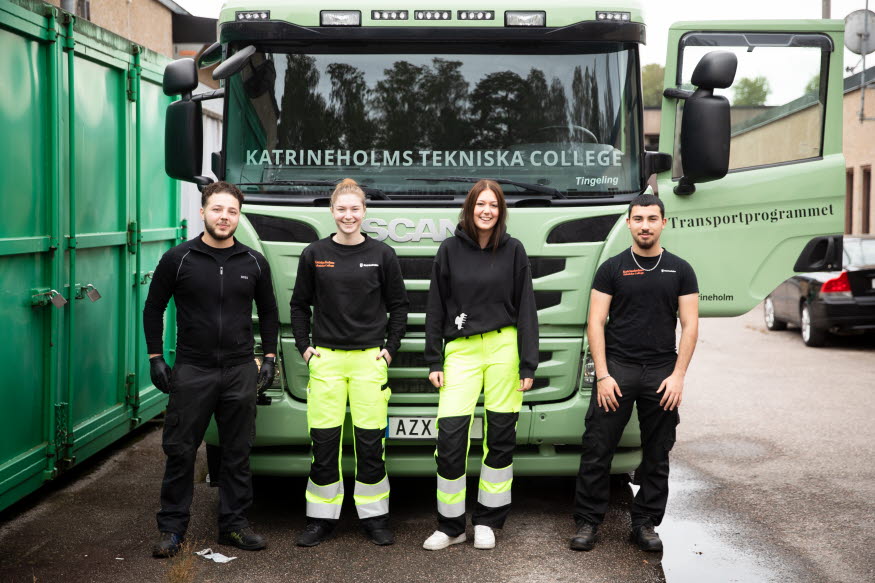 Fyra elever framför en lastbil. 