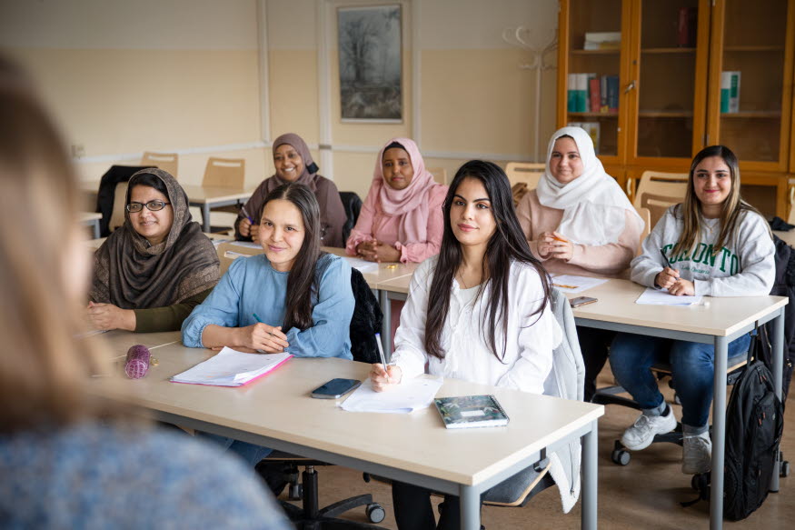 En grupp vuxna elever i ett klassrum. 