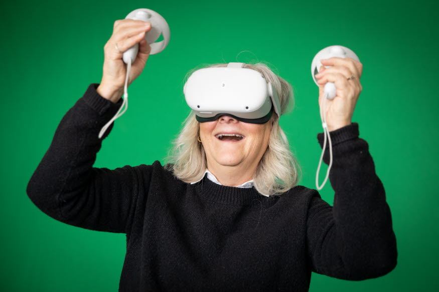 En person testar VR-glasögon och verkar tycka det är väldigt roligt.