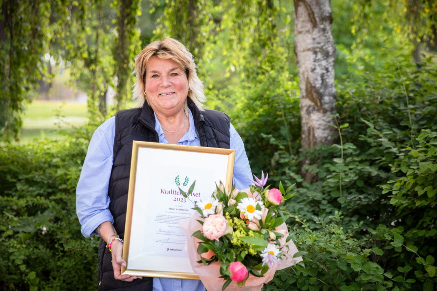 En person med blommor och diplom. 