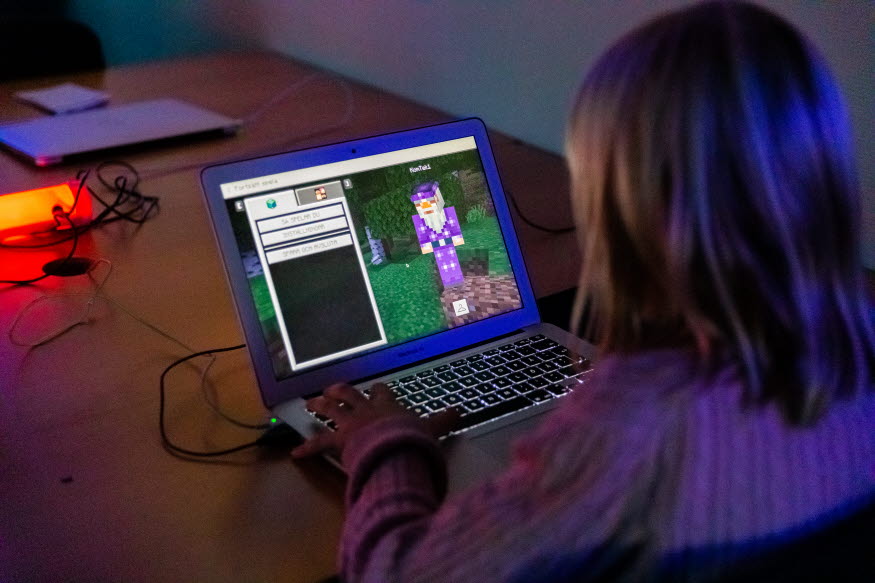 Ett barn som spelar Minecraft på en dator.