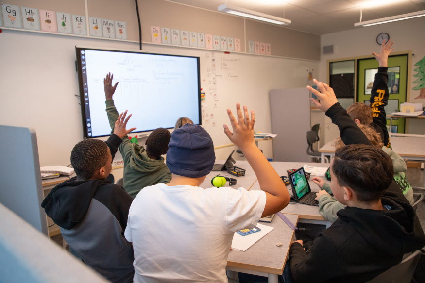 Elever som räcker upp handen. 