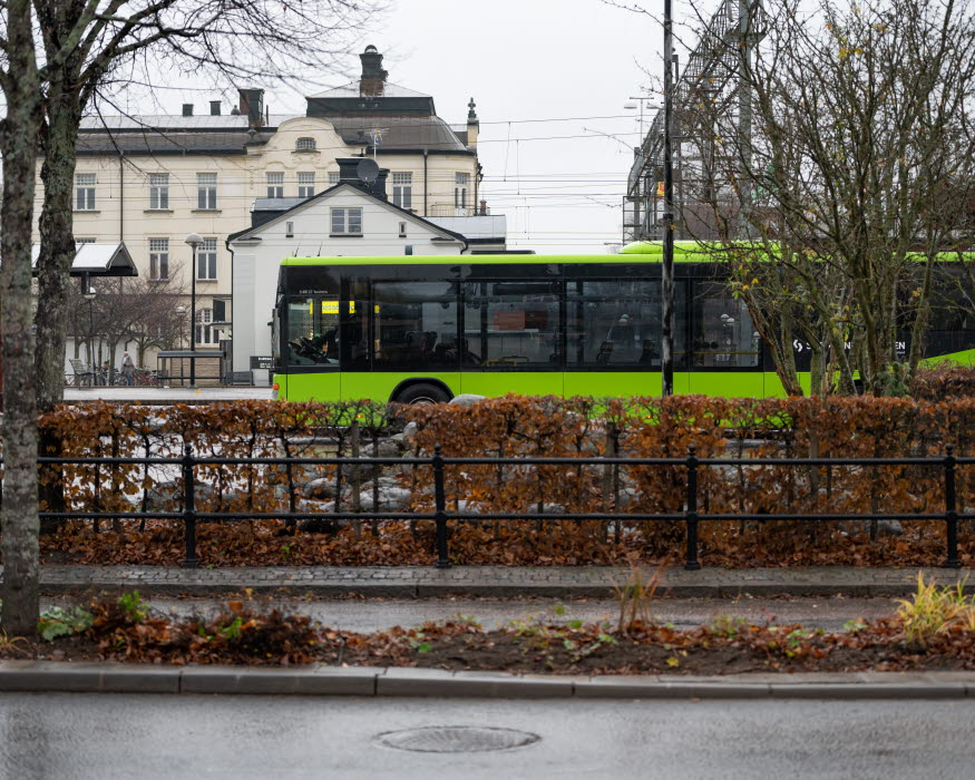 En grön buss som åker i stadsmiljön i Katrineholm