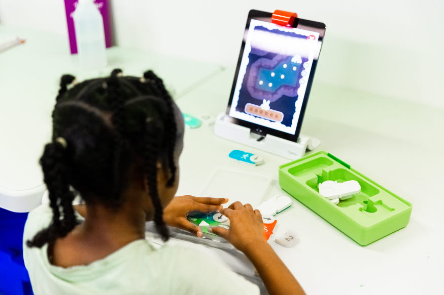 Ett barn programmerar med en läsplatta. 