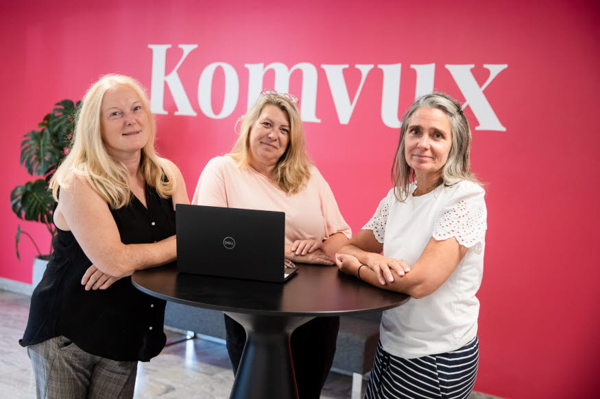 Tre personer står vid en dator. I bakgrunden texten Komvux. 