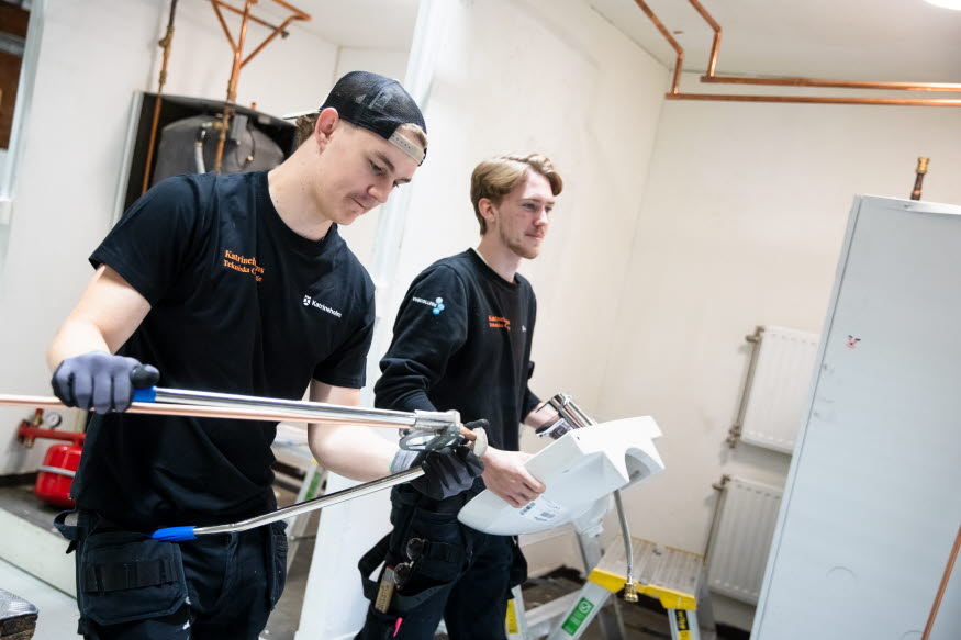 Elever bär handfat och kröker rör. 